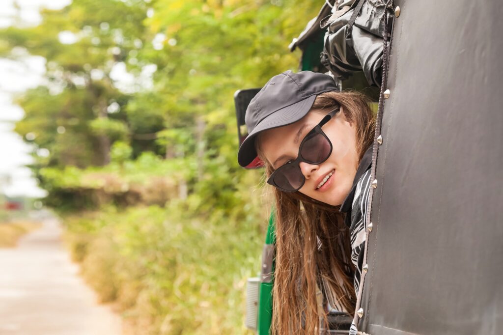 Caucasian woman tourist with sunglasses rides in tuk tuk public transport in Sri Lanka