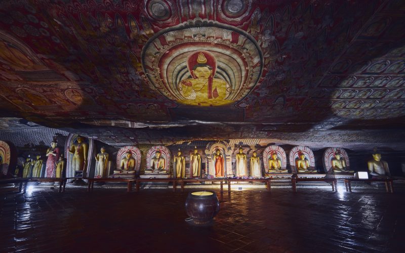 Statues and paintings inside of largest and best preserved cave temple complex in Sri Lanka